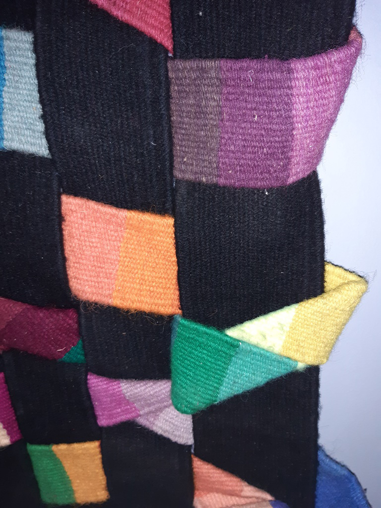 Object-slits-interlaced-with-strips-woven-brightly-colored-wool.jpg